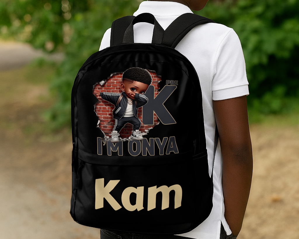 Black backpack with a melanin boy cartoon character in front of a brick wall, wearing sneakers and jacket, with text “PRE K I’M ONYA” and a personalized name at the bottom.
